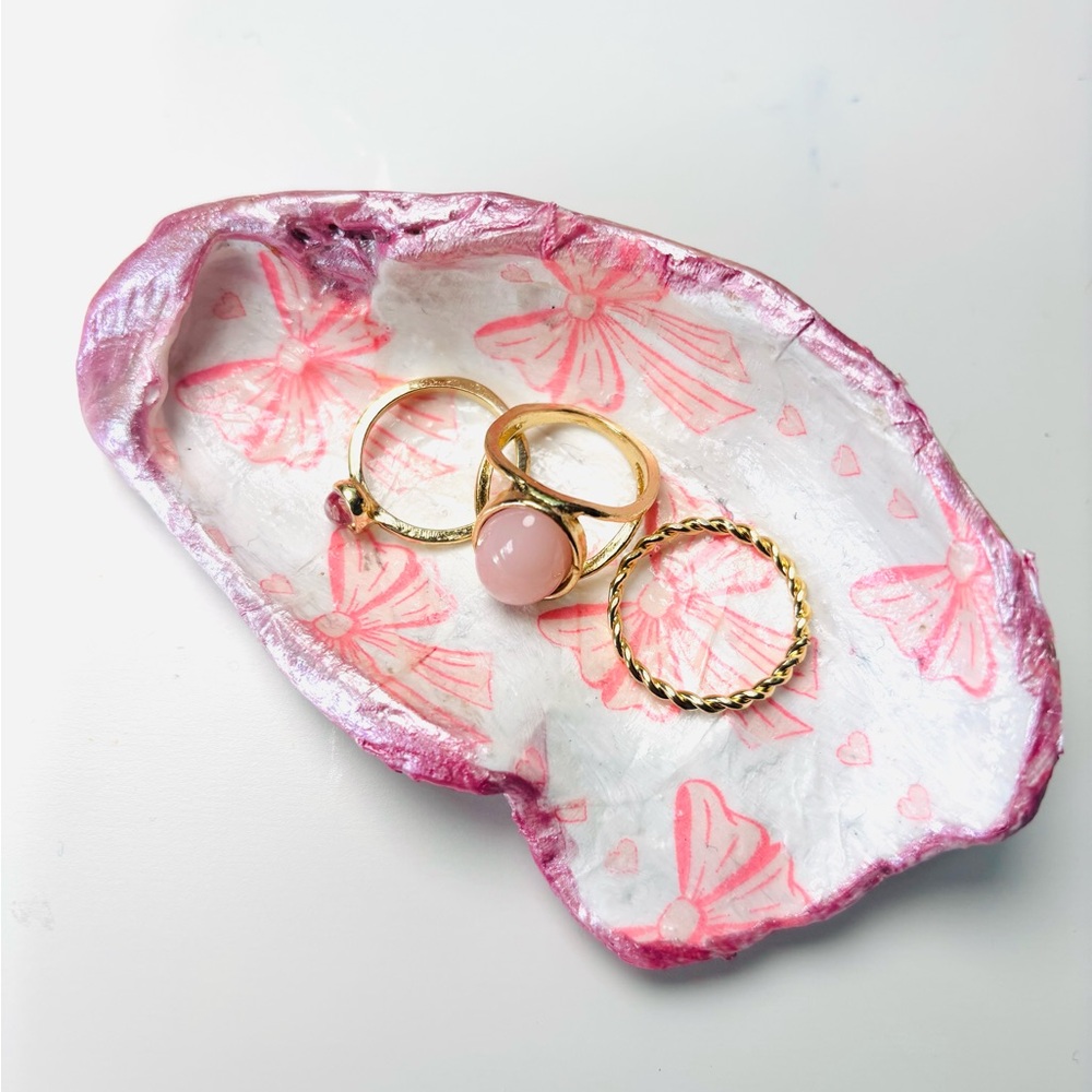 Handcrafted oyster shell ring dish with pink bow decoupage design.